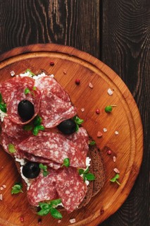 Sandwich, grain bread, with cream cheese and salami, black olives, micro-greens, top view,