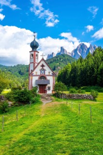 Scenic st. Magdalena church nestled in a lush green meadow, framed by the majestic odle mountain