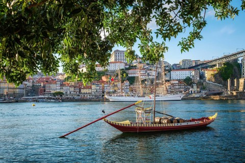View of Porto city and Douro river with traditional boats with port wine barrels and sailing ship