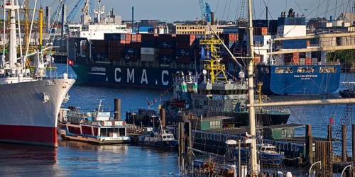 Container ship of the shipping company CMA CGM with many different ships in the port of Hamburg,