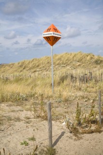 Beach marker sign in sand dunes near Scheveningen Holland