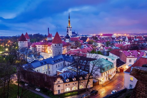 Aerial view of Tallinn Medieval Old Town illuminated in evening with dramatic sky, Estonia