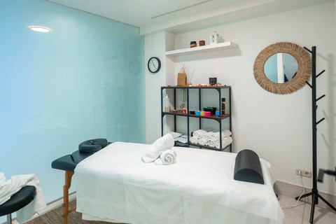 Clean and modern spa room interior featuring a professional massage table prepared for relaxation,