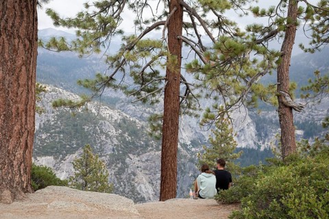 Yosemite National Park, California - A young couple on the rocks above Yosemite Valley in Yosemite