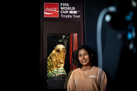 A football fan poses for a photograph with the original FIFA World Cup 2026 Trophy during the