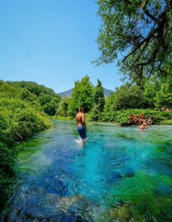 Muzina, Albania, tourists bathe in the Syri i Kaltër, THE BLUE EYE, is the country's most