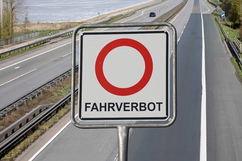 (photo montage) Sign with the inscription FAHRVERBOT exempted in front of an empty motorway