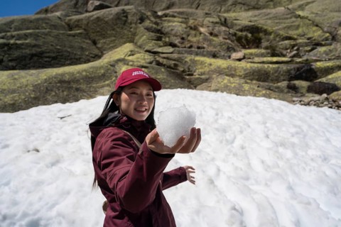 An Asian woman enjoys her winter adventure in the Sierra de Gredos, Spain. She's dressed warmly,