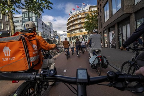 Ride your bike on the central cycle path on Lange Viestraat, Vredenburg, in the city centre of