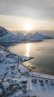 A stunning aerial view captures the serene beauty of a Nordic landscape, showcasing snow-covered