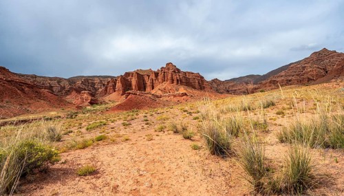 Eroded mountain landscape with sandstone cliffs, red and orange rock formations, Konorchek Canyon,