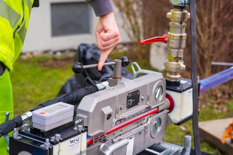 Person points to a mechanical device outdoors, Wend Glasfasermontage during the installation of