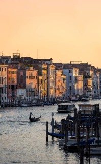 View of the Grand Canal with gondoliers at sunset, picturesque evening mood, view from the Rialto