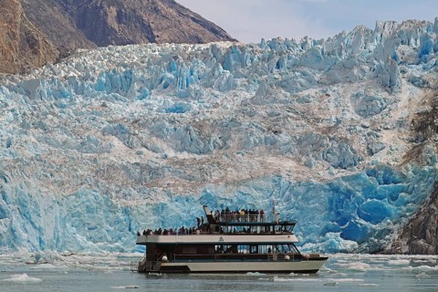 Small boat in front of a glacier calving into the sea, Tracy Arm Fiord, Tongass National Forest,