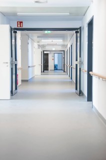 Long white hospital corridor with open doors and handrails, new Calw hospital, Germany