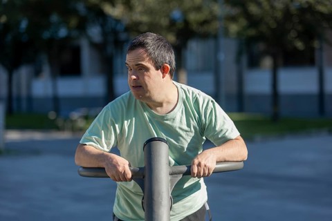 A person enjoys outdoor exercise at a community day center, focusing on well-being and engagement.