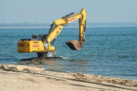 Excavator used in the repair the beach in Ystad, Ystads Saltsjöbad, a popular tourist destination,