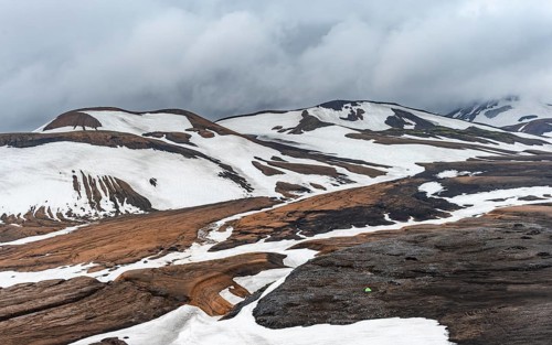 Dramatic volcanic landscape with mountains and snow, at Höskuldsskáli hut in Hrafntinnusker,