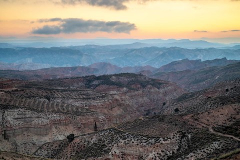 Sunrise, wide hilly desert landscape with dry vegetation, Gorafe desert, semi-desert, Granada,