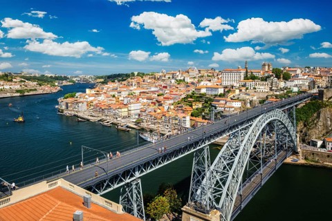 View of Porto city and Douro river with moored sailing ship and Dom Luis bridge I from famous