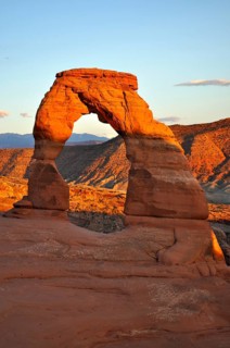 The Delicate Arch in warm sunset light in a desert-like environment, Arches National Park, Utah,