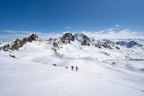 Two ski tourers in mountain landscape with snow, view of peaks Piz Grialetsch and Piz Vadret,