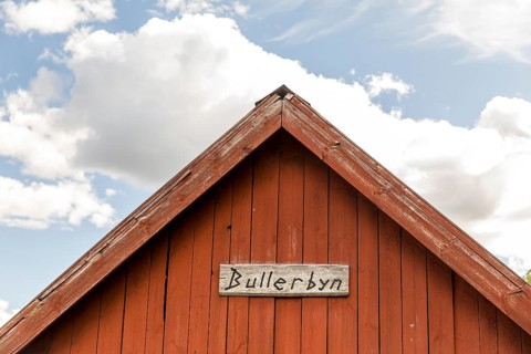 Gable on a Swedish red wooden house with the lettering Bullerbyn, these houses in Sevedstorp are