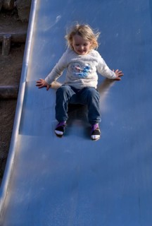 Little girl, 3 years, blonde, jumper, Disney, Elsa, ice queen, slides on slide, playground,