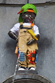 Bronze statue Manneken Pis by Jérôme Duquesnoy, fountain figure of a urinating boy in costume,