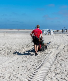 Worker with cleaning machine on the sandy beach of the North Sea, Sankt Peter-Ording,