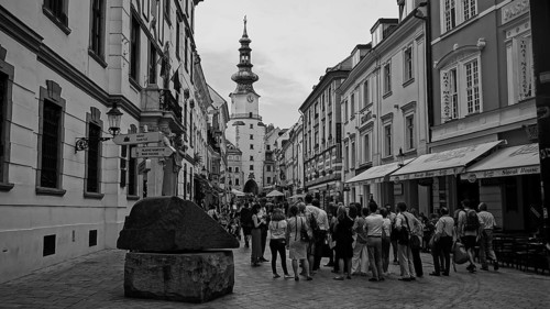 Monochrome, a group of tourists on a guided tour through the historic old town of Bratislava,