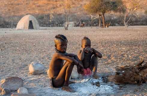 Himba children at an early morning fire, traditional Himba village, Kaokoveld, Kunene, Namibia