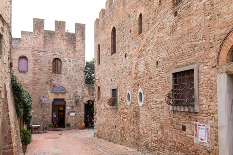 Narrow alleyways and houses decorated with battlements in the old town centre of Certaldo, Tuscany,