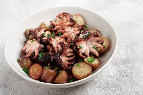 Baby grilled octopus with golden baked potatoes and fresh herbs, Maltese cuisine, homemade, no