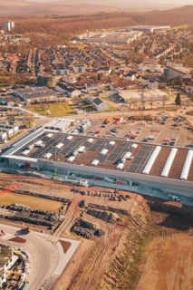 Aerial view of an industrial complex with solar systems and parking spaces in an urban area, PV Bau