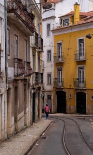 Woman with rucksack, tram tracks, Old Town, Lisbon, Portugal