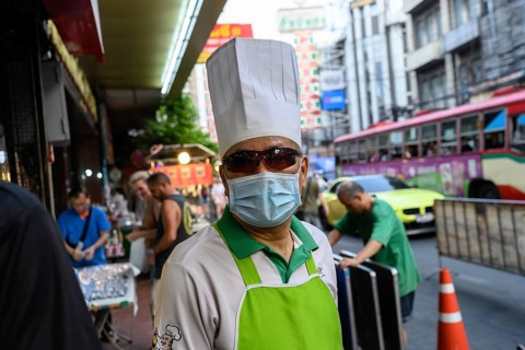 Bangkok, Thailand. February 18th 2025. A local chef wearing sunglasses a face mask and chef's hat,