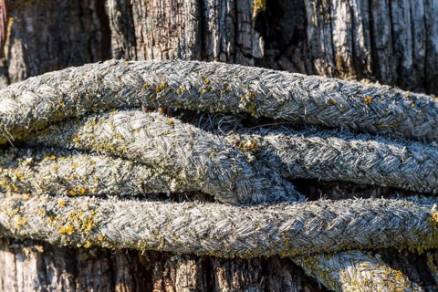 Old rope is wrapped around a fence post