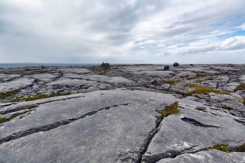 Bizarrely shaped limestone slabs, hiking trail along the coastline, limestone coast of the Burren,