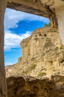 Sandstone cliffs with cave dwellings overlooking the village of arguedas in navarre, spain, seen
