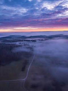 View of a misty landscape with wide fields, hills and enchanting morning sky, Calw, Black Forest,