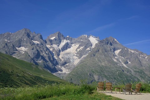 Rest area with table and chairs with view of Pointe Piaget and La Meije as seen from the botanical