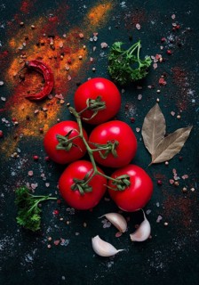 Tomato branch, on dark green background, with spices, top view, food background, vertical, no