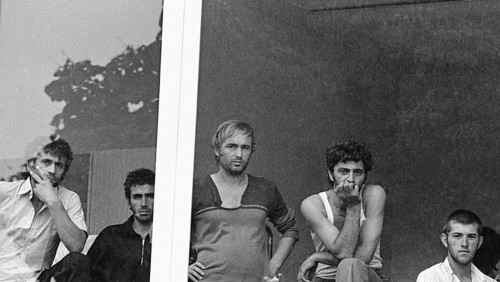 Geseke, DEU - 15.07.1990 - Albanian refugees look out a window at the regional office for refugees