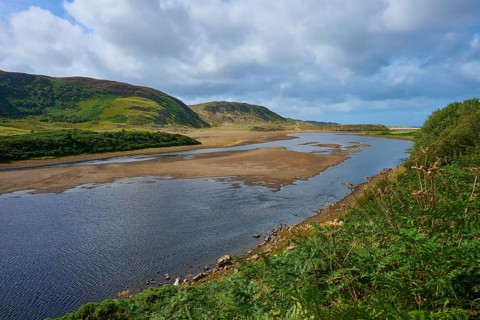A calm river snakes through a rolling landscape under a cloudy sky, River Naver, Bettyhill, Thurso,
