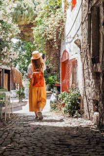 Back view of unrecognizable woman tourist using a smartphone to capture the beauty of an old city