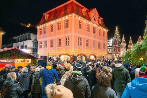 Impressive building with festive lighting, crowd below. Christmas atmosphere, Christmas market,