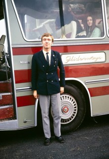Full body portrait of a male coach driver standing next to his coach, Gliderways Coaches of