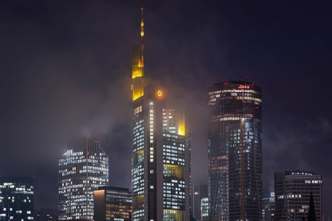 Low clouds envelop the shining towers of Frankfurt's banking skyline in the evening. Frankfurt am