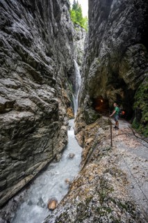 Waterfall and mountain stream Hammersbach in a canyon, mountaineers on a hiking trail in a gorge,